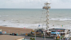 A coastal area with a lighthouse, beach, and various shops including a fish and chips restaurant.