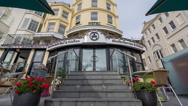 A hotel entrance with a sign reading "Amsterdam Bar & Kitchen."