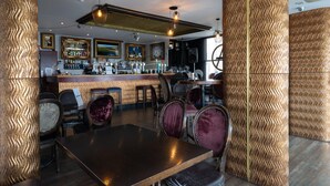 A bar area with a counter, bar stools, and a seating area with tables and chairs.