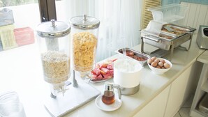 A buffet setup with various food items and a tea dispenser.