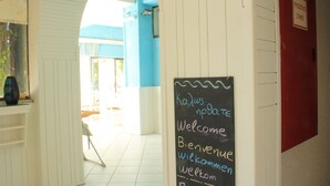 A hallway with a chalkboard sign reading "Welcome" in multiple languages.