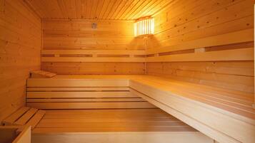 A sauna with wooden benches and a sloped floor.