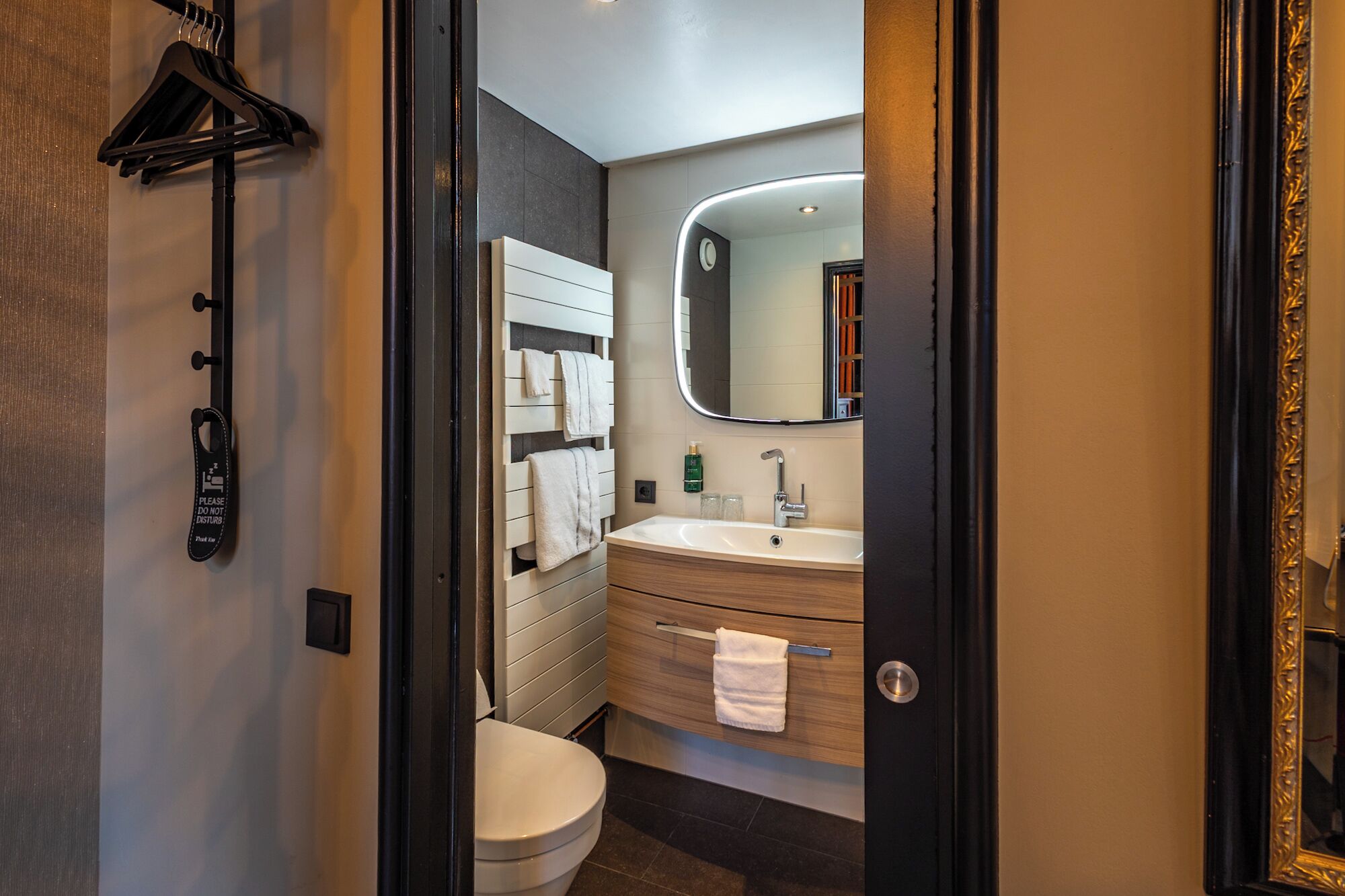 Un baño moderno con inodoro, lavamanos y barra para toallas.