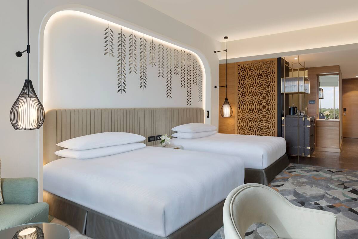 Een moderne hotelkamer met een groot bed, een zithoek, een kitchenette en een badkamer.