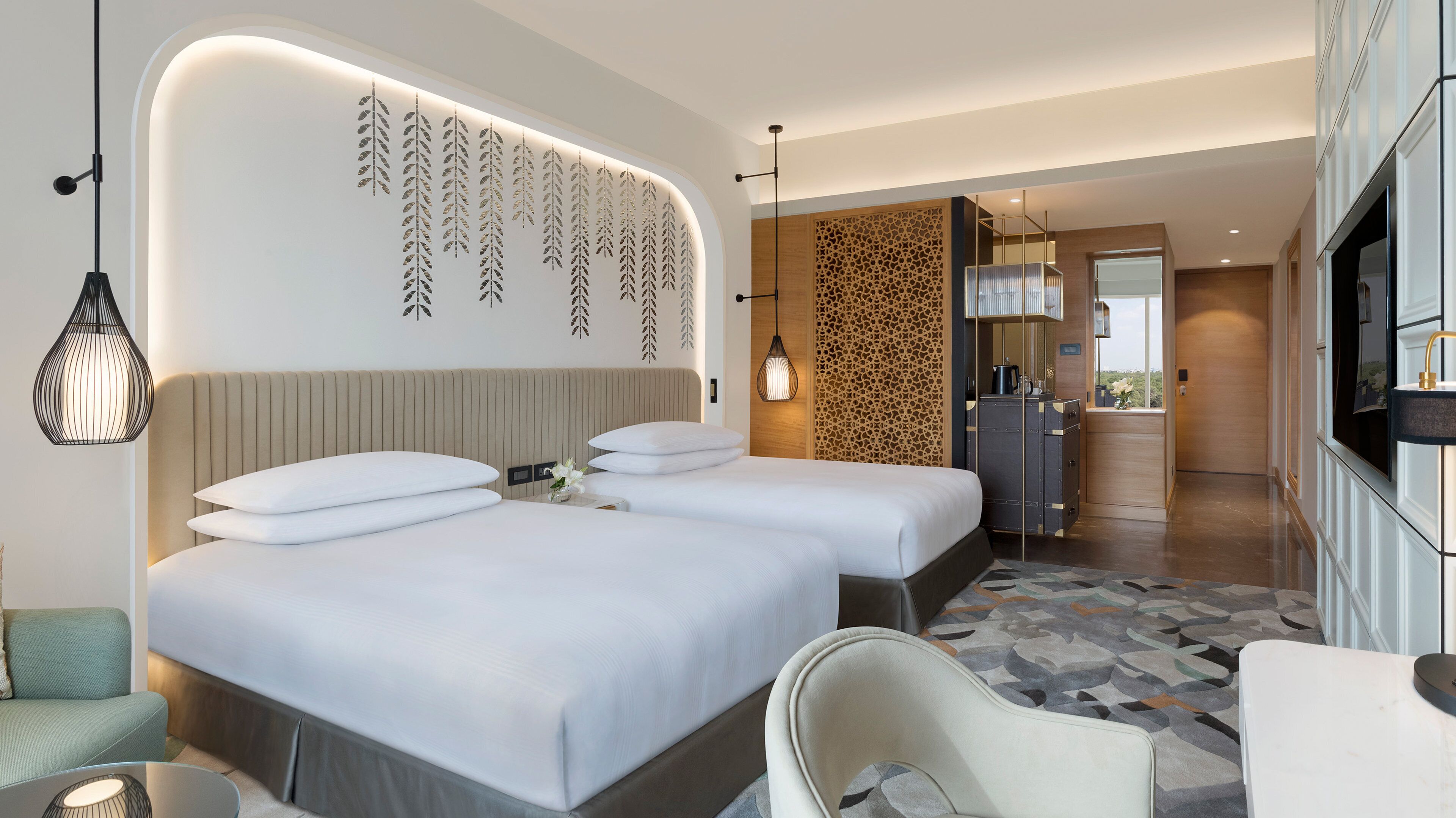 Habitación de hotel con una cama grande, zona de estar, kitchenette y baño.