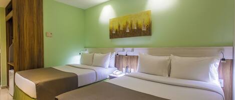 A hotel room with two beds, a painting on the wall, and a staircase.