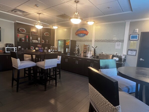 A breakfast bar with seating, a microwave, and a refrigerator. - Baymont by Wyndham College Station (College Station)