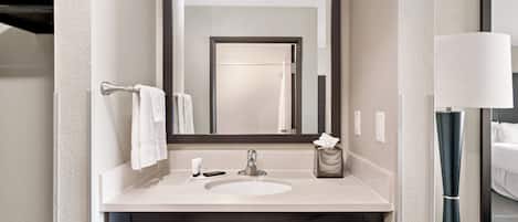 Une salle de bain moderne avec un grand miroir, un lavabo et un porte-serviettes.