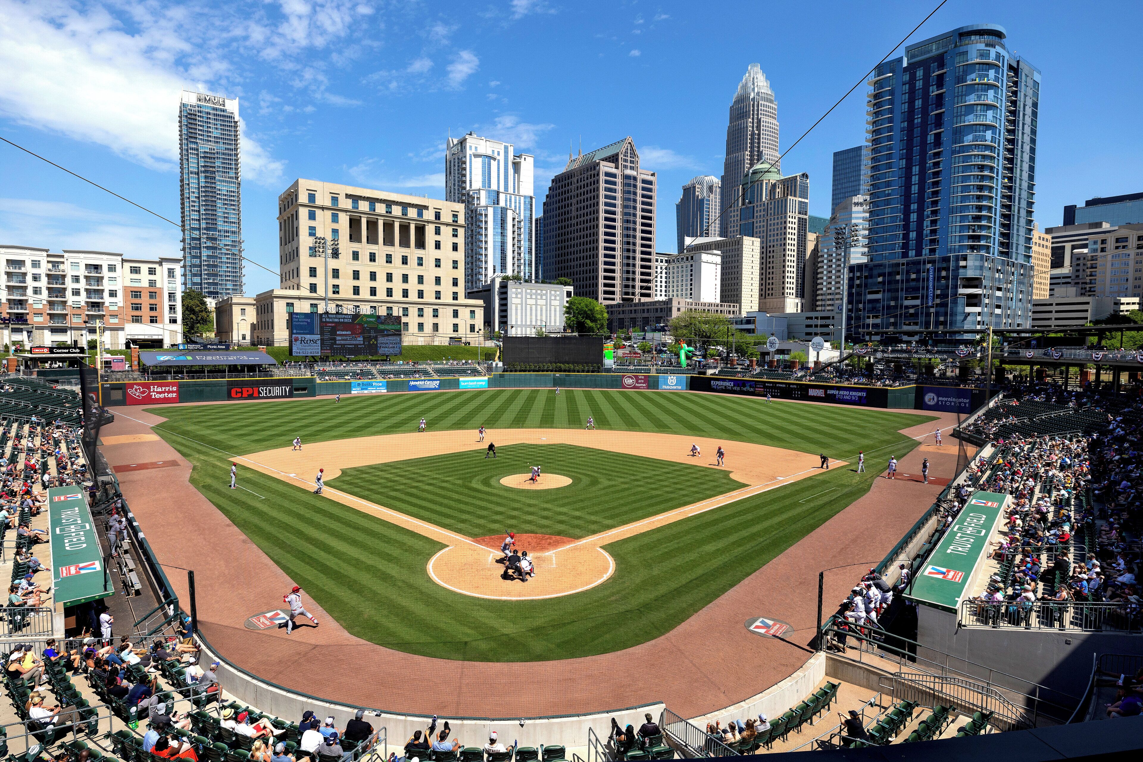 A baseball stadium with a city skyline in the background.