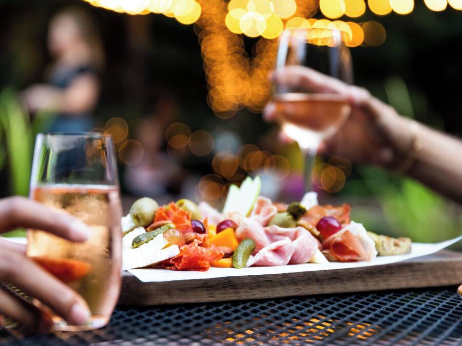 A table with a charcuterie board and glasses of drink.