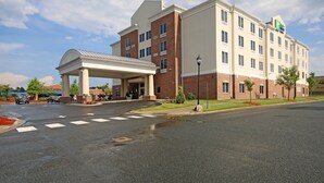 A hotel with a covered entrance, multiple floors, and a parking lot. - Holiday Inn Express & Suites Charlotte North by IHG (Charlotte)