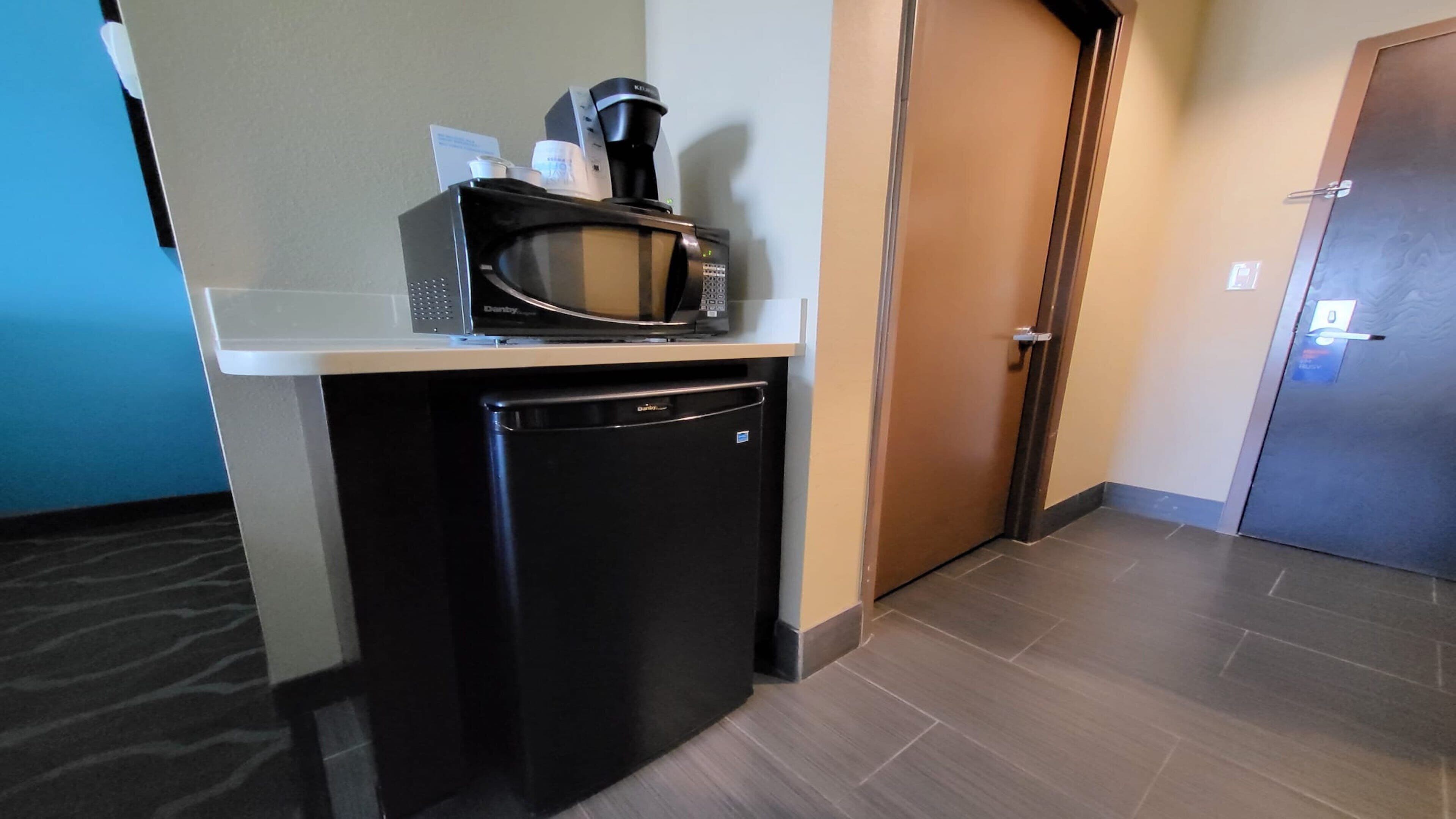 A compact kitchenette with a microwave, coffee maker, and a small refrigerator.