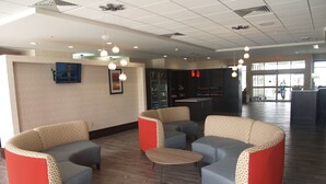 Un hall d’entrée avec des espaces d’attente, un comptoir de réception et une grande fenêtre.