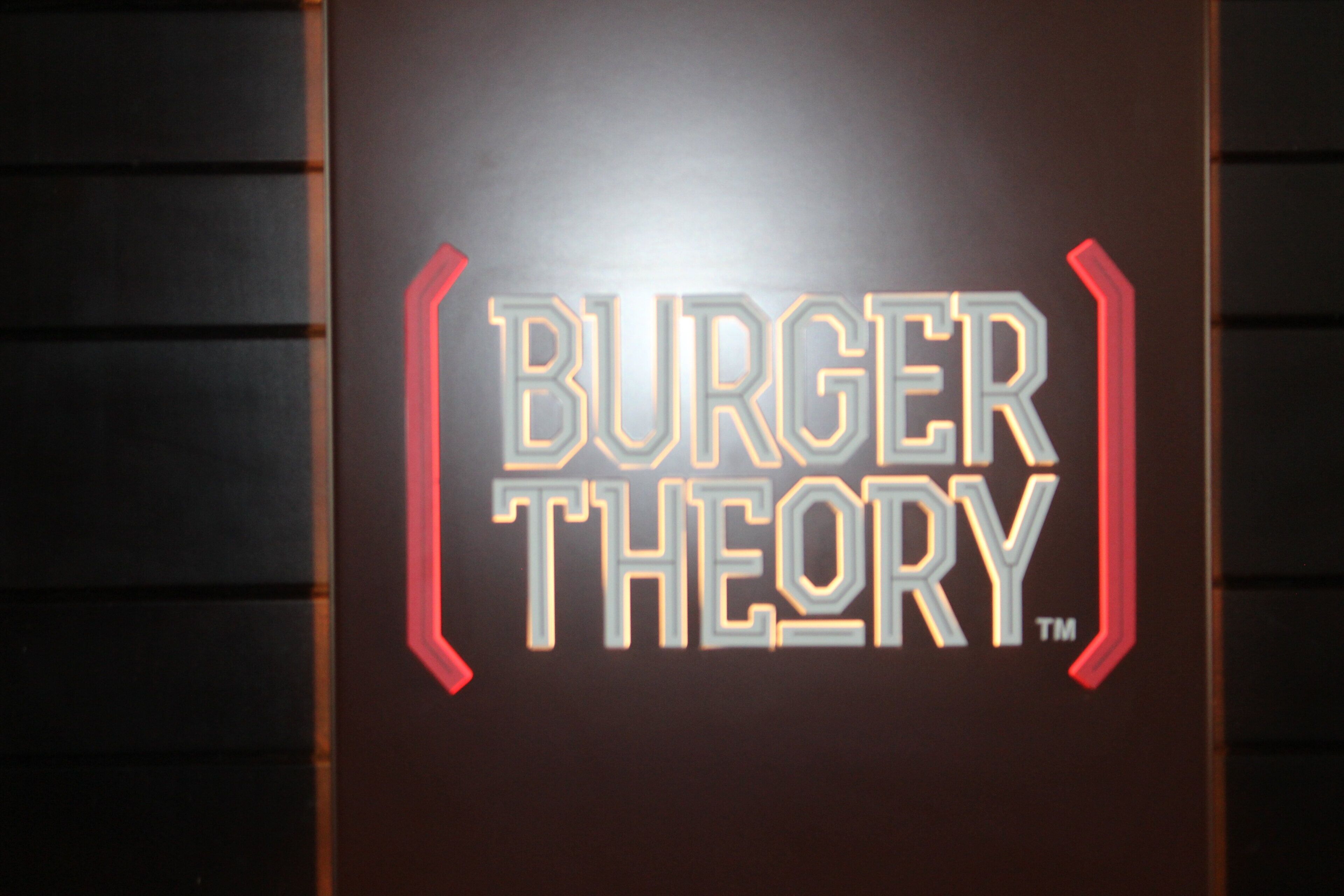 A sign with the text 'BURGER THEORY' in stylized lettering.