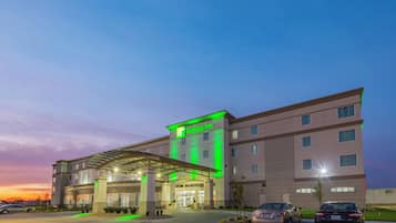 Un hotel Holiday Inn con un diseño moderno, que presenta una entrada cubierta y varios pisos.