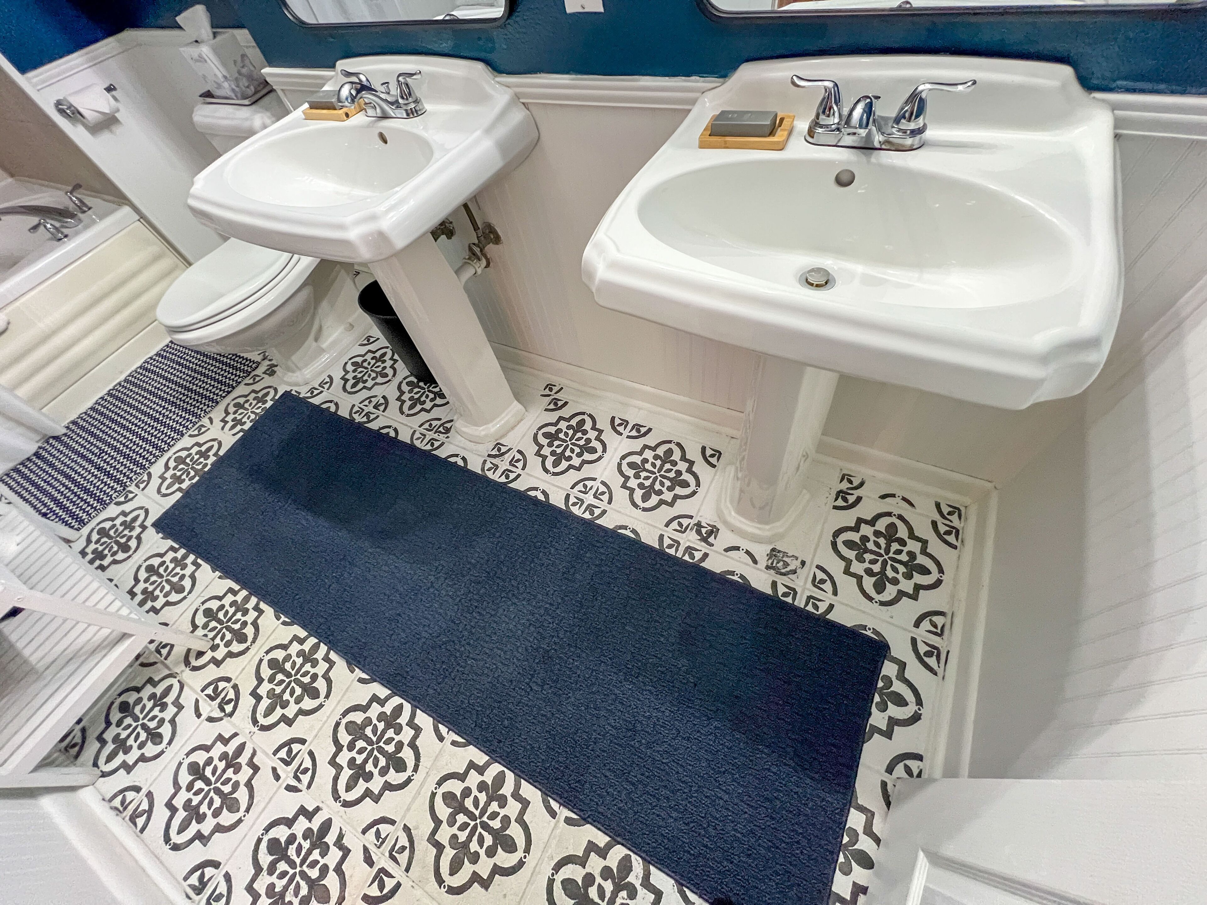 Un bagno con due lavandini, un water e piastrelle decorative.