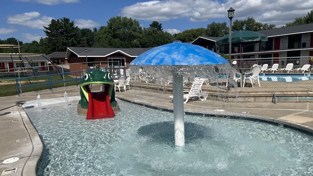 A water play area with a frog slide and a water fountain.
