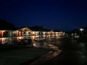 A motel with multiple units, each featuring a balcony and a red door.