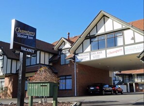 Un bâtiment sur lequel est apposée une enseigne indiquant qu’il y a des chambres disponibles au Chambers Motor Inn.