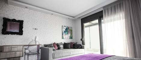 A modern bedroom with a bed, a desk, and a window.