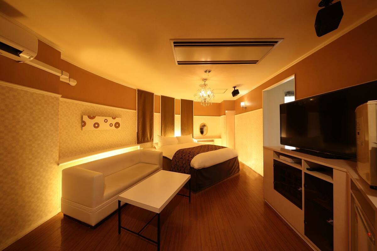 Une chambre d’hôtel équipée d’un lit, d’un canapé, d’une télévision et d’un mini-bar.