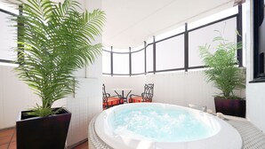 Ein Wellnessbereich mit Whirlpool, zwei Kübelpflanzen und einer Sitzecke mit Stühlen und Tisch.