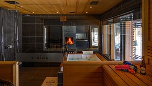 Une salle de spa moderne avec un banc en bois, un jacuzzi et une cheminée.