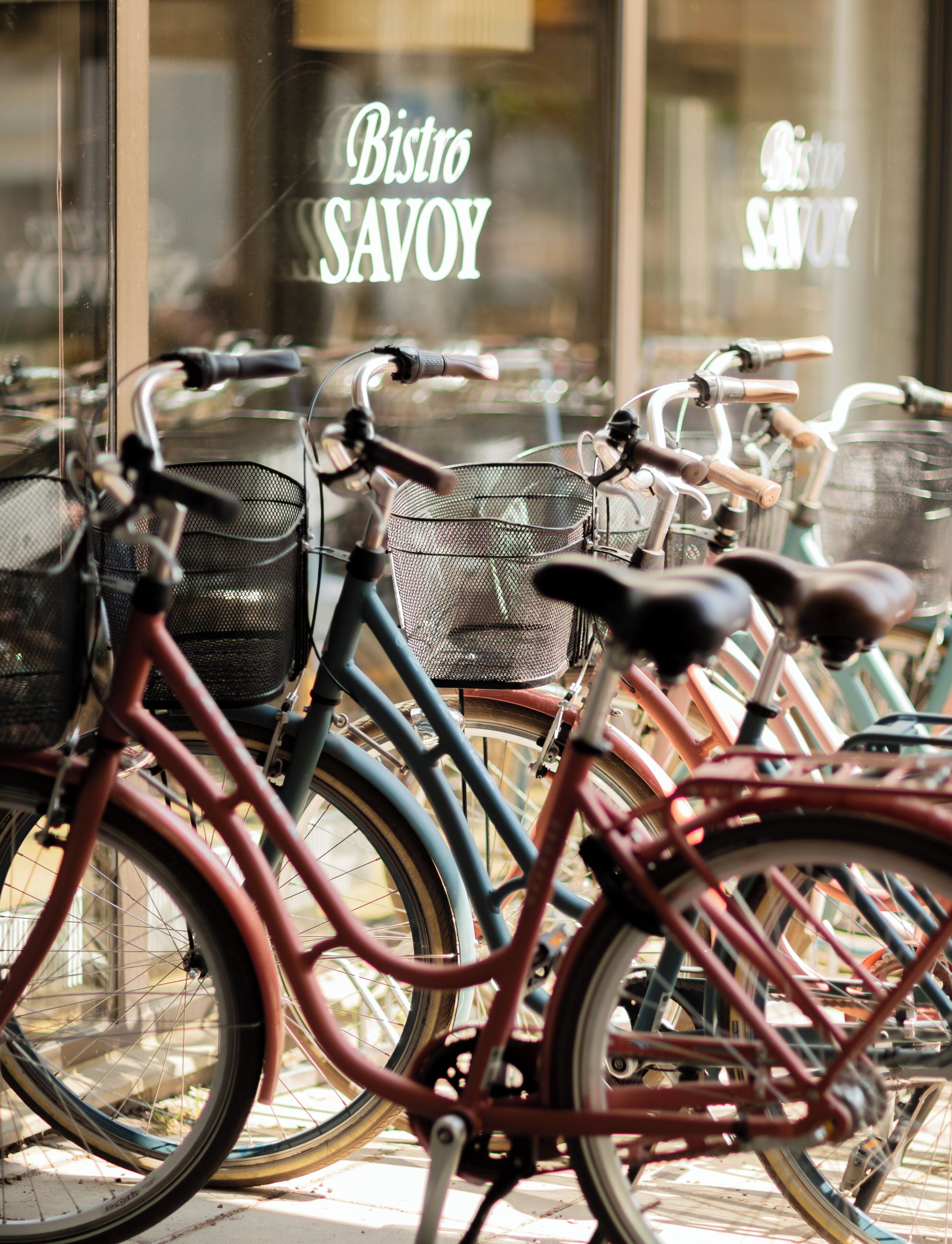 Bicicletas estacionadas frente a un edificio con un cartel que dice "Bistro SAVOY".