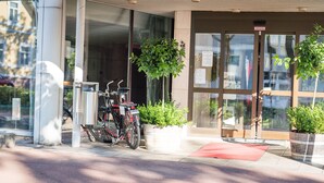 A hotel entrance with a sign reading "HOTEL SAVOY," a bicycle parked outside, and potted plants near the entrance. - Hotel Savoy (Mariehamn)