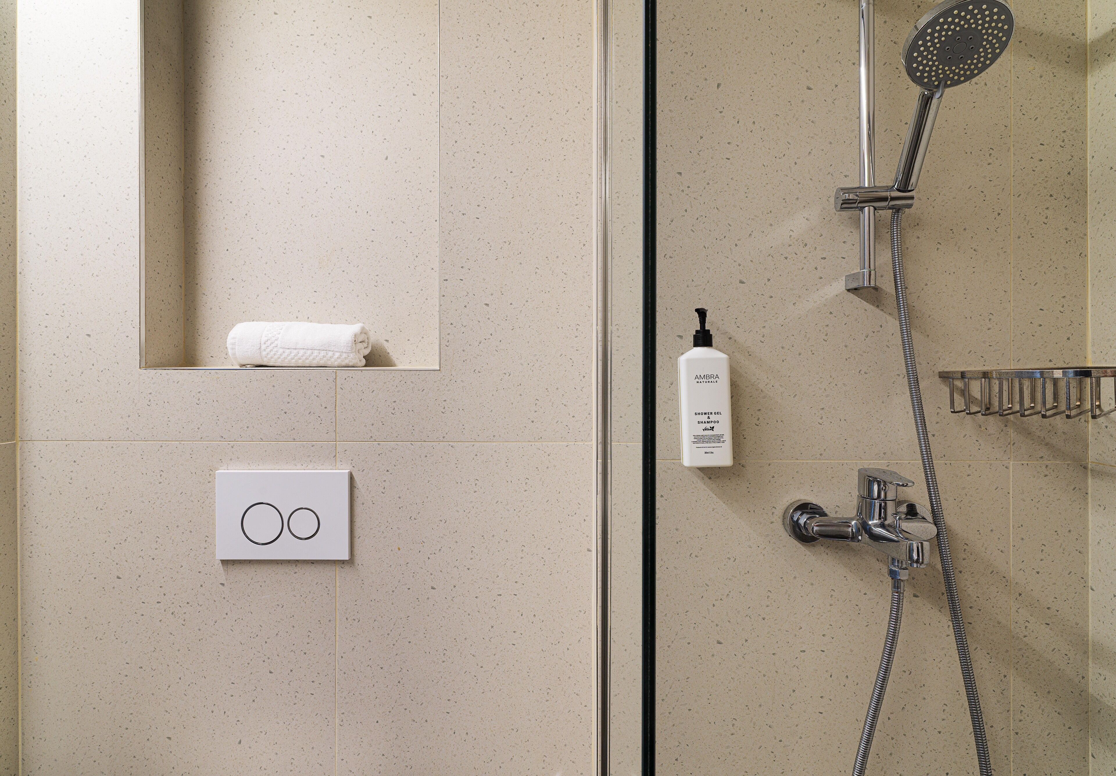 Une salle de bain avec une douche, une serviette et un distributeur de savon.