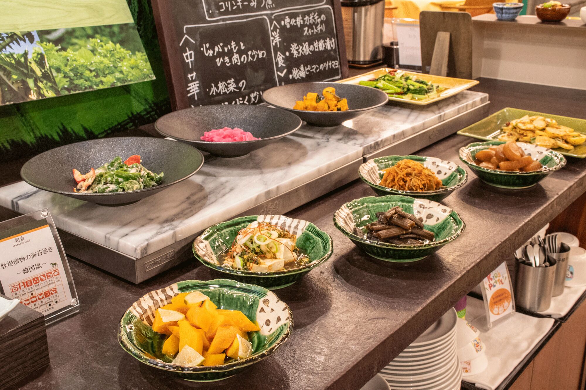 A buffet with various dishes, including salads, vegetables, and other prepared foods.