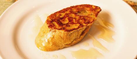 A single pancake on a white plate with syrup.