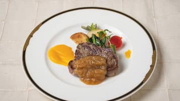 Ein Teller mit einem Steak, Gemüse und Soße.