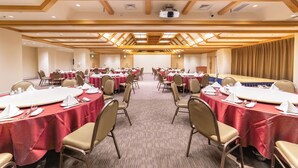 A conference room with round tables, beige chairs, and red tablecloths. - Hotel Continental (Fuchu)