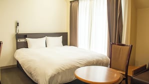 A hotel room with a bed, a round table, a chair, a telephone, and a window with curtains. - Hotel Continental (Fuchu)