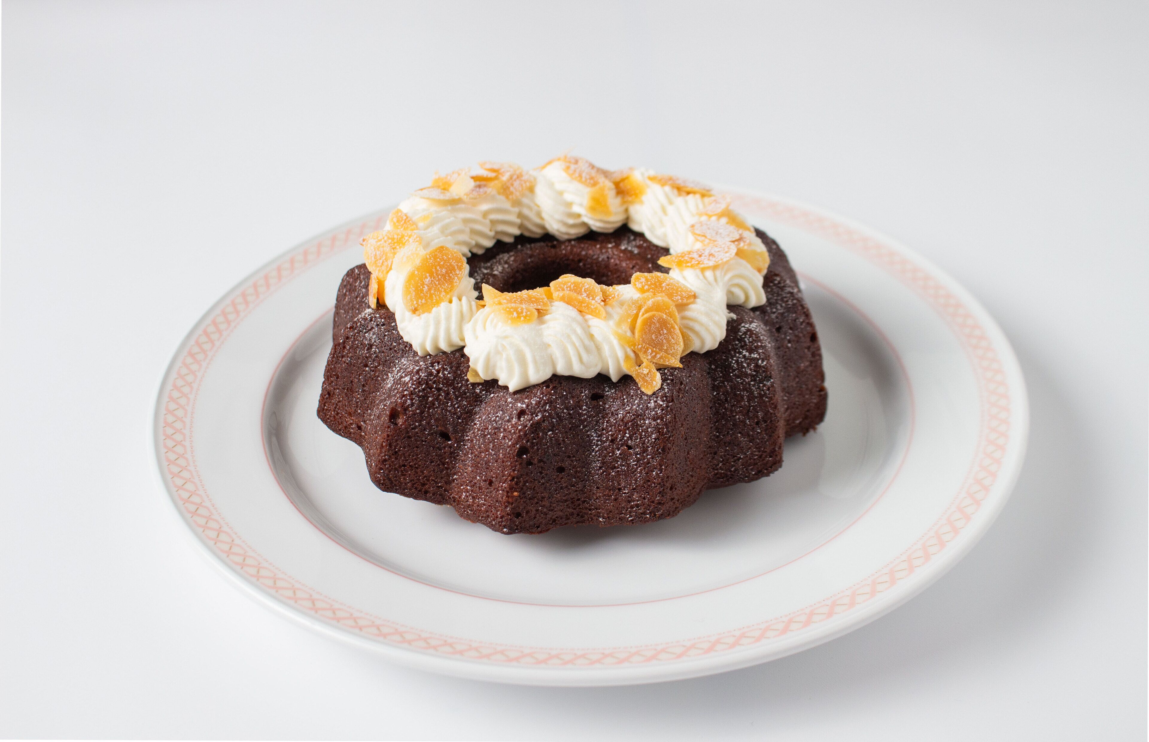 Un pastel Bundt en un plato blanco con un estampado rojo.