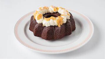 A bundt cake on a white plate with a red pattern.