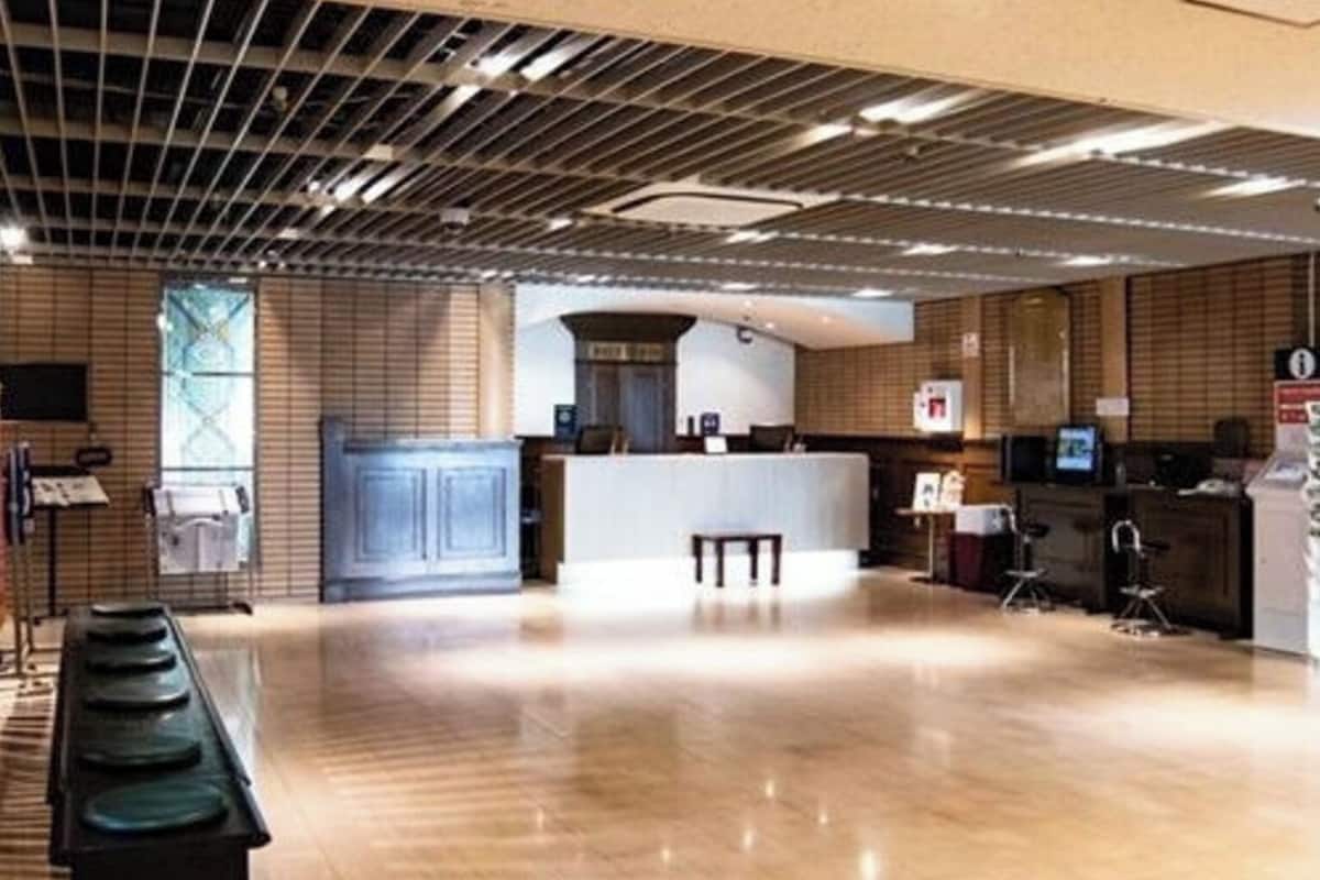 Un vestíbulo amplio con una mesa de recepción, mostrador y zona de estar.
