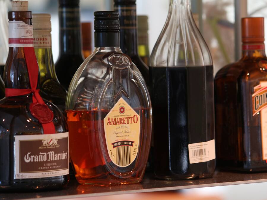 Variedad de botellas de licor en una estantería.