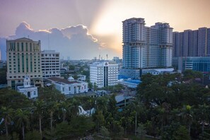 A cityscape with modern high-rise buildings, a classical building, and dense greenery. - Grand Inna Medan (Medan)