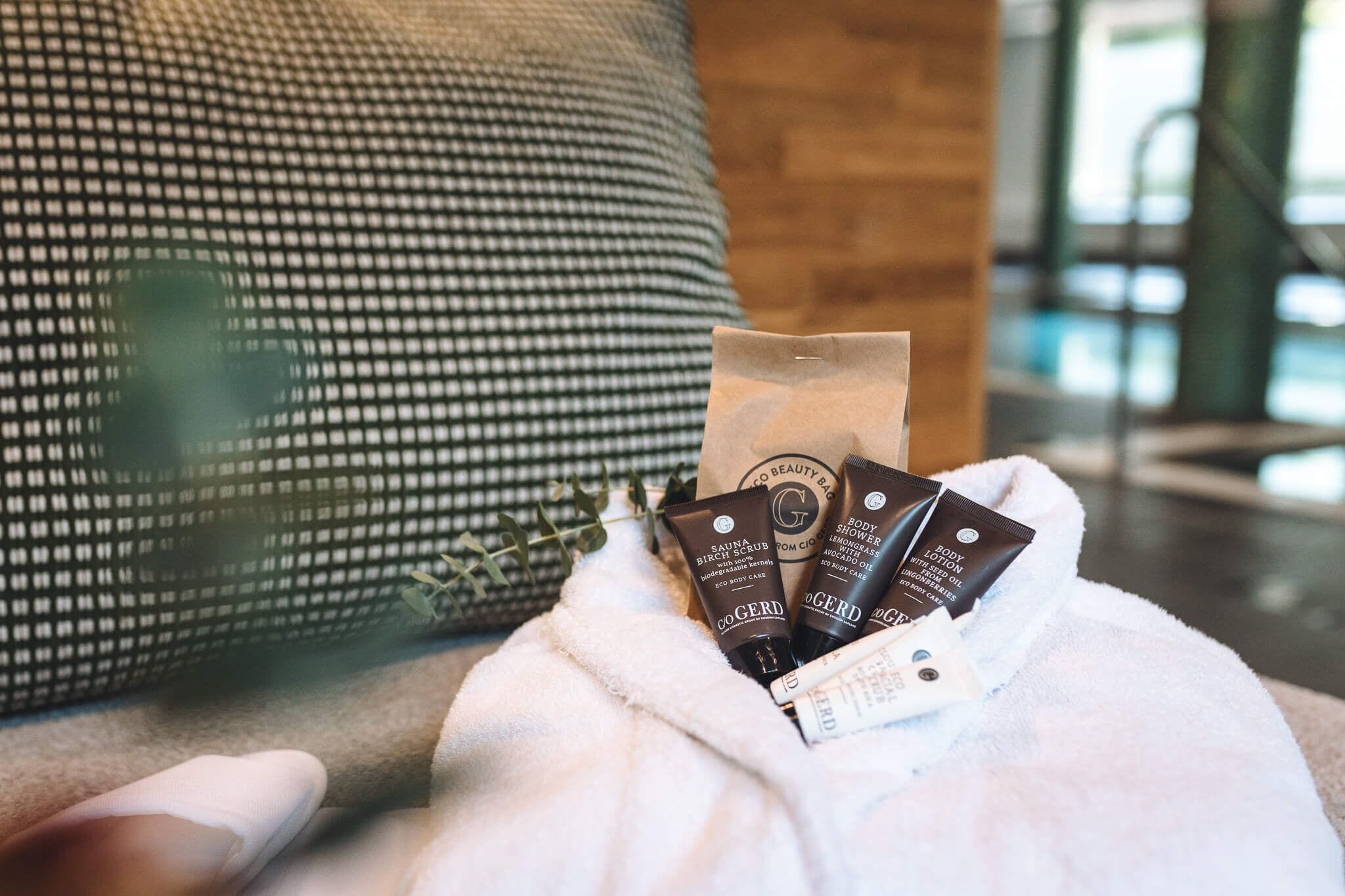 Una persona sosteniendo una toalla blanca con tres productos de cuidado corporal.