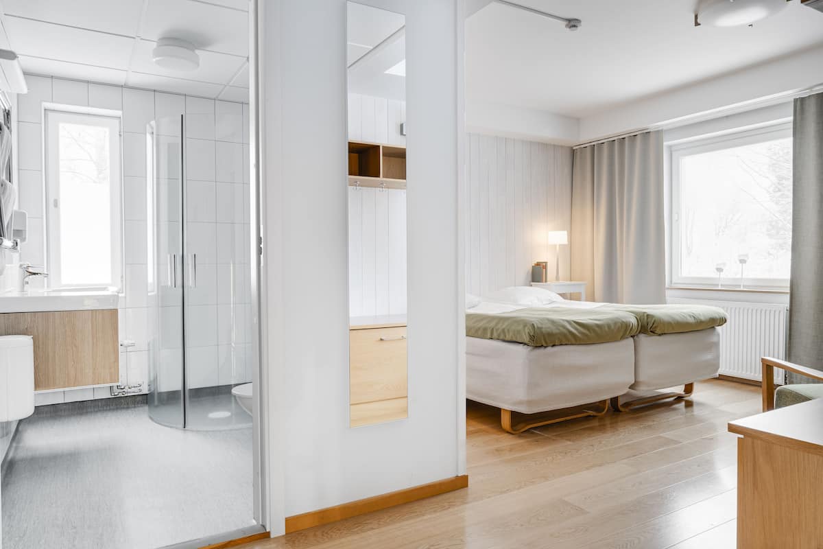 Ein modernes Schlafzimmer mit Bett, Nachttisch und einem Fenster mit Vorhängen.
