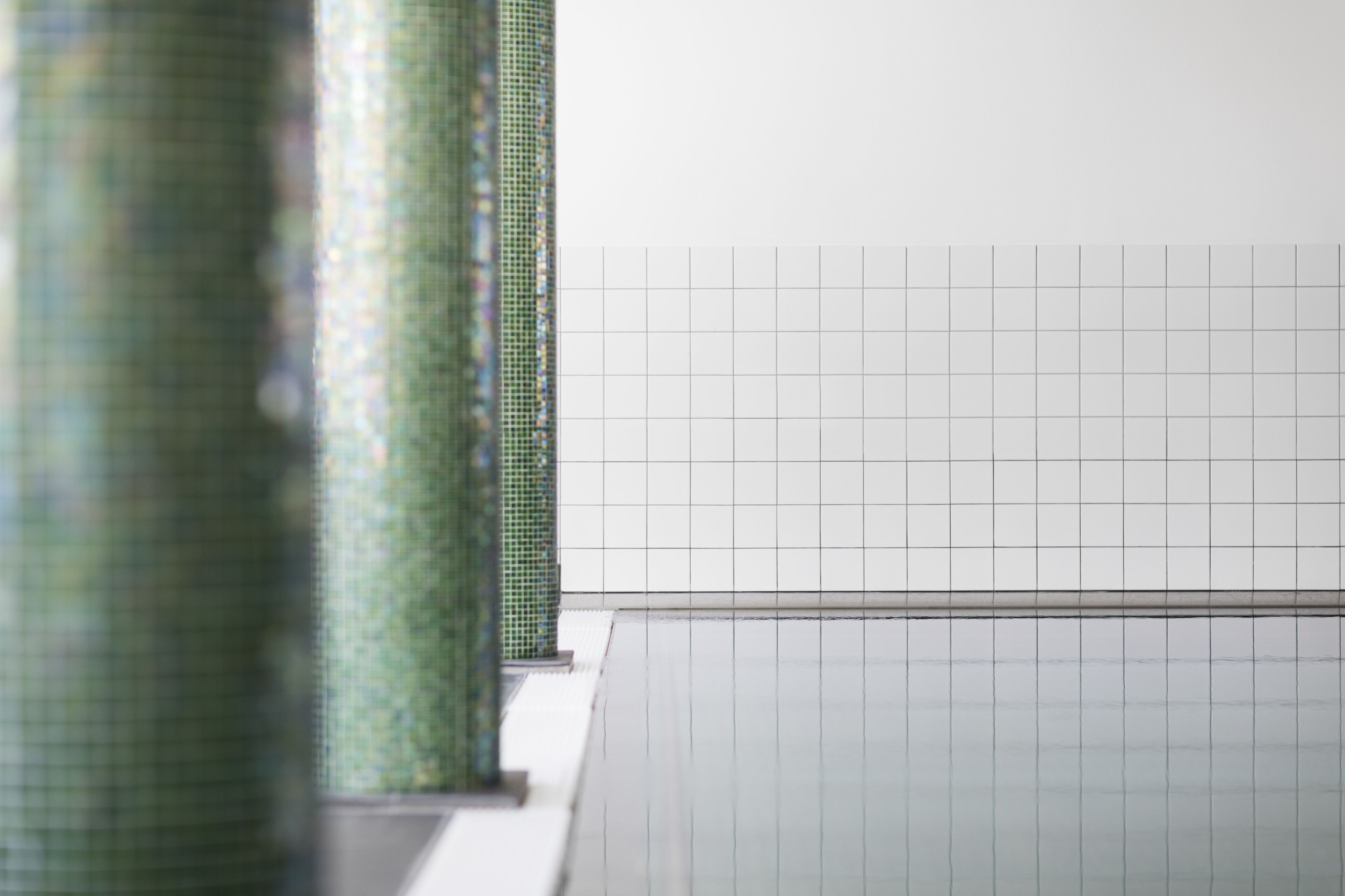 A tiled wall with a grid pattern, likely part of a building's interior.