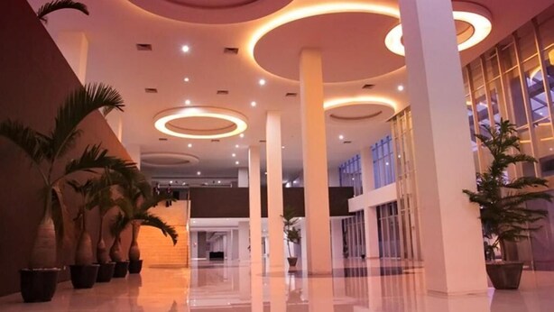 A modern interior with circular ceiling lights, large pillars, and potted plants. - Truntum Padang (Padang)