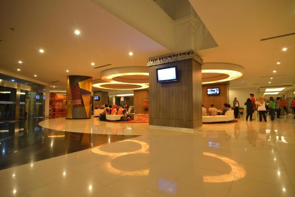 A spacious lobby with a central seating area, multiple screens, and a modern design.