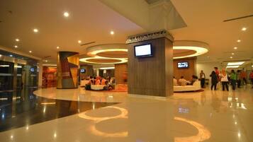 A spacious lobby with a central seating area, multiple screens, and a modern design.
