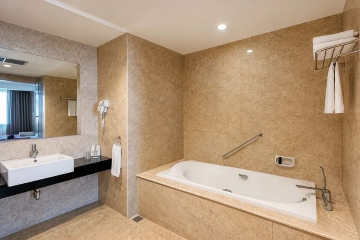 A modern bathroom with a bathtub, a sink, and a mirror.