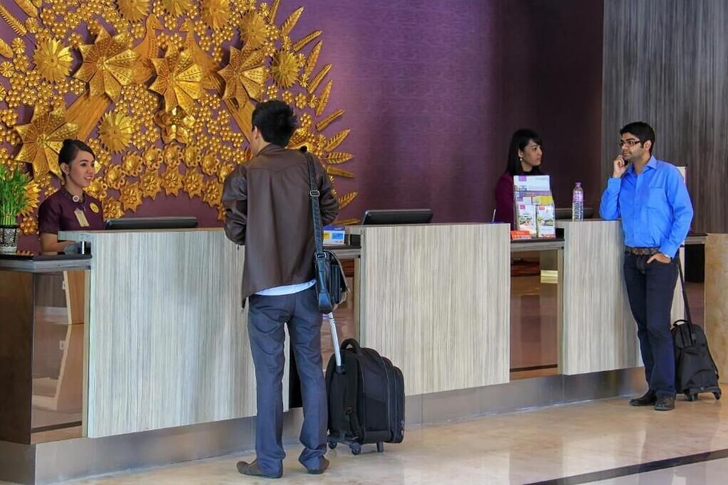 A reception area with a decorative golden wall, a reception desk, and a waiting area.