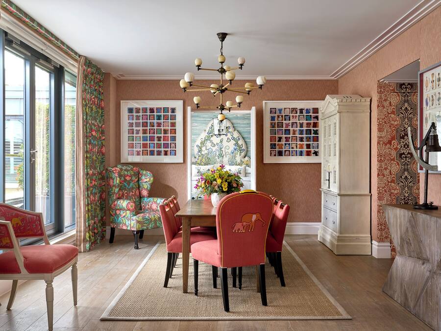 Comedor con candelabro, cortinas con motivos florales y alfombra estampada.