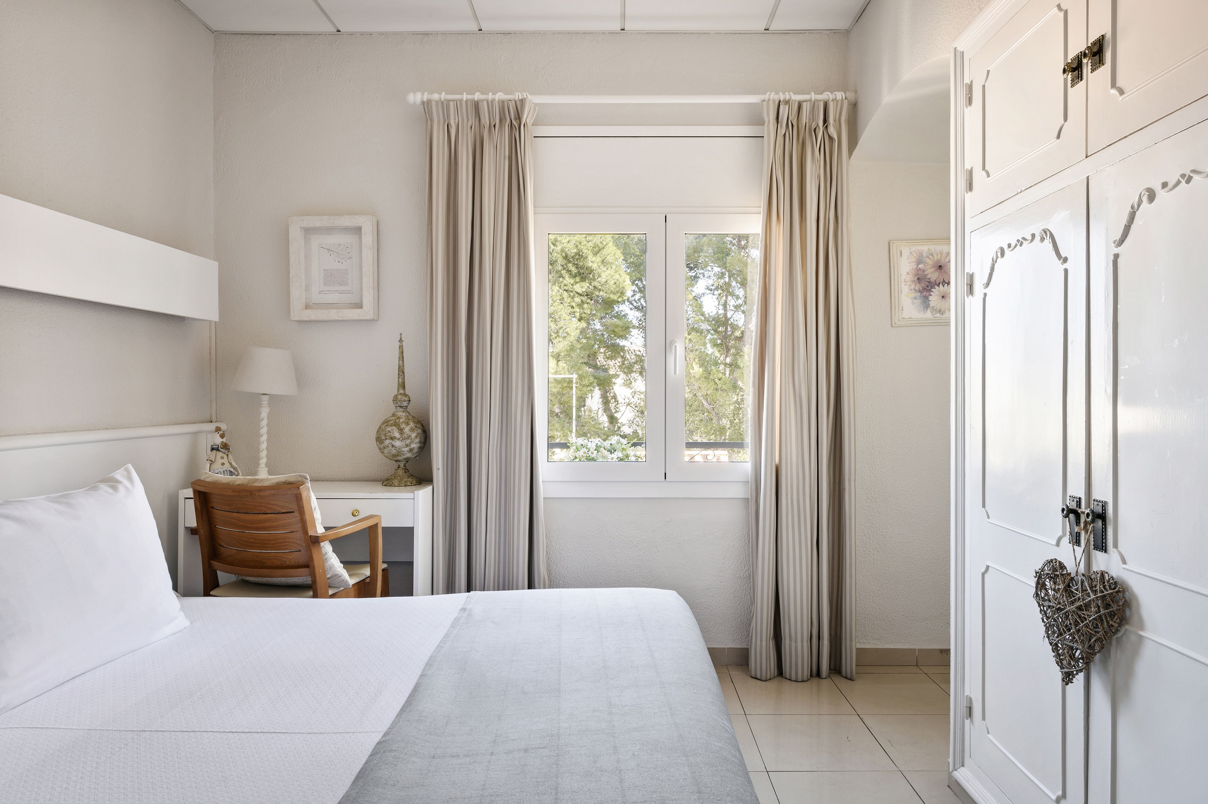 Un dormitorio con cama, escritorio, silla y armario.